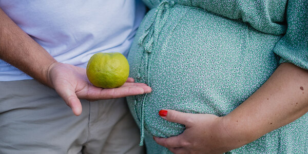 expecting couple with apple
